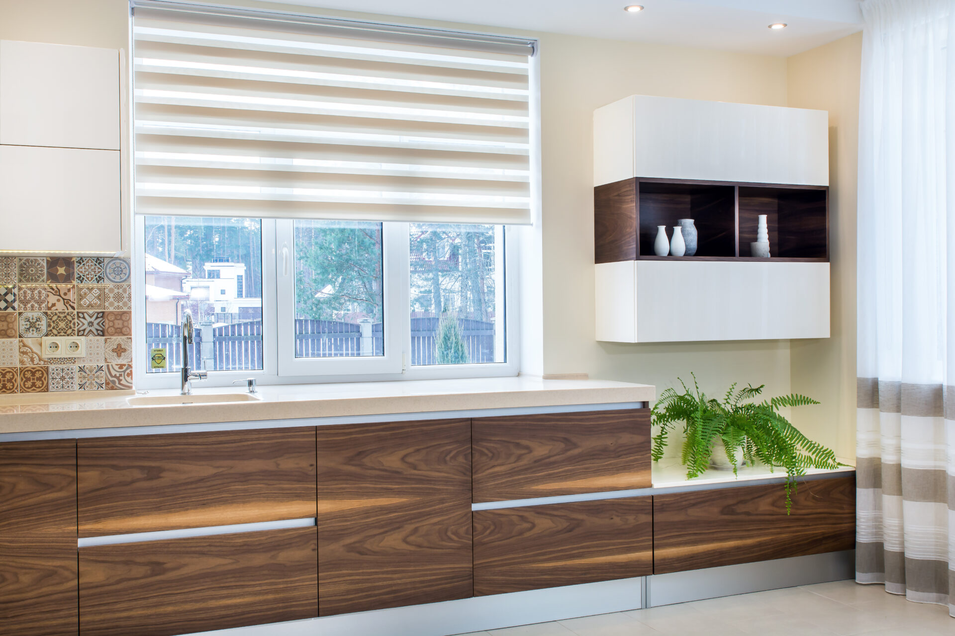 Modern kitchen furniture design in light interior with Somfy blinds. Wholesale Blind Factory